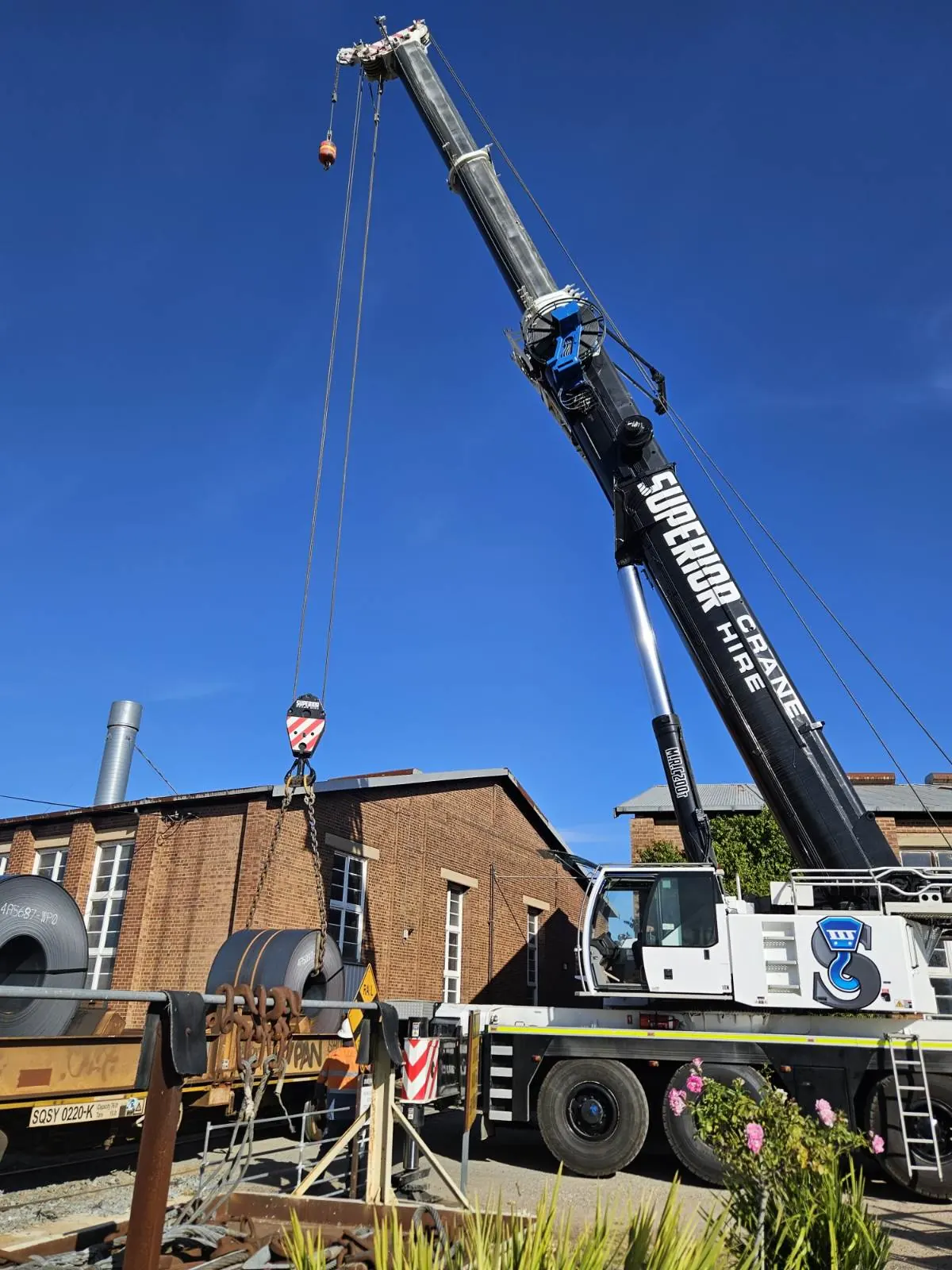 A crane working beside a brick building