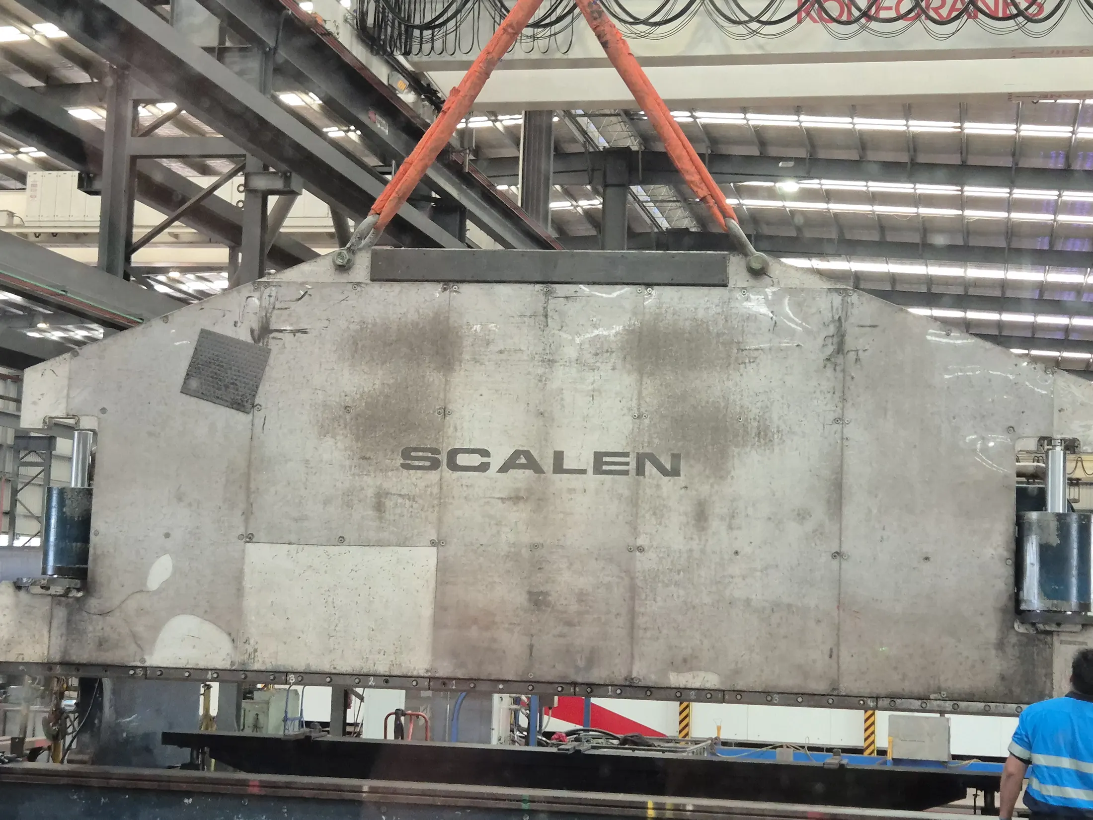 Heavy machinery being lifted inside a factory